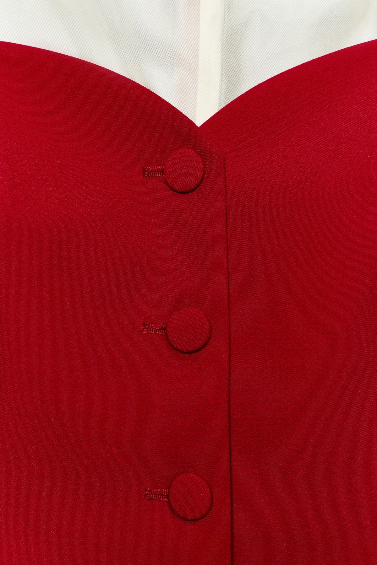 Gilet rouge — détail de l’encolure et des boutons